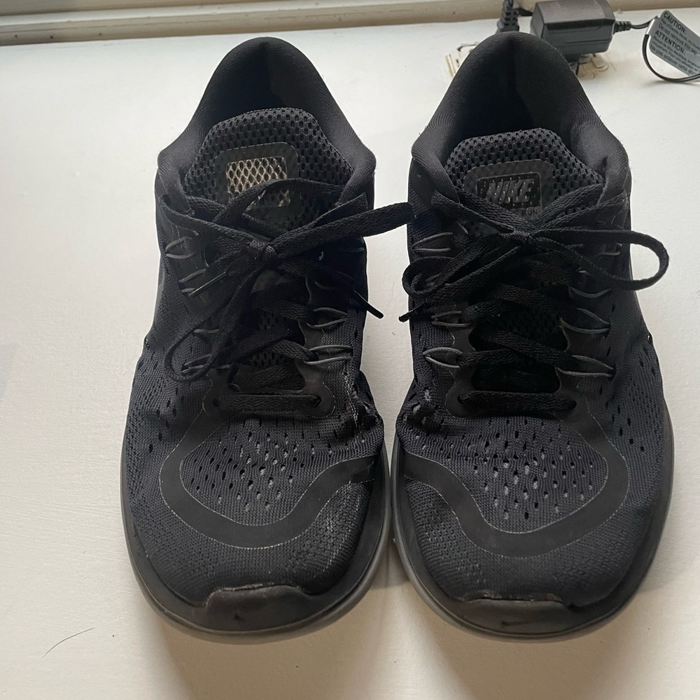 Women’s all black Nike tennis shoes